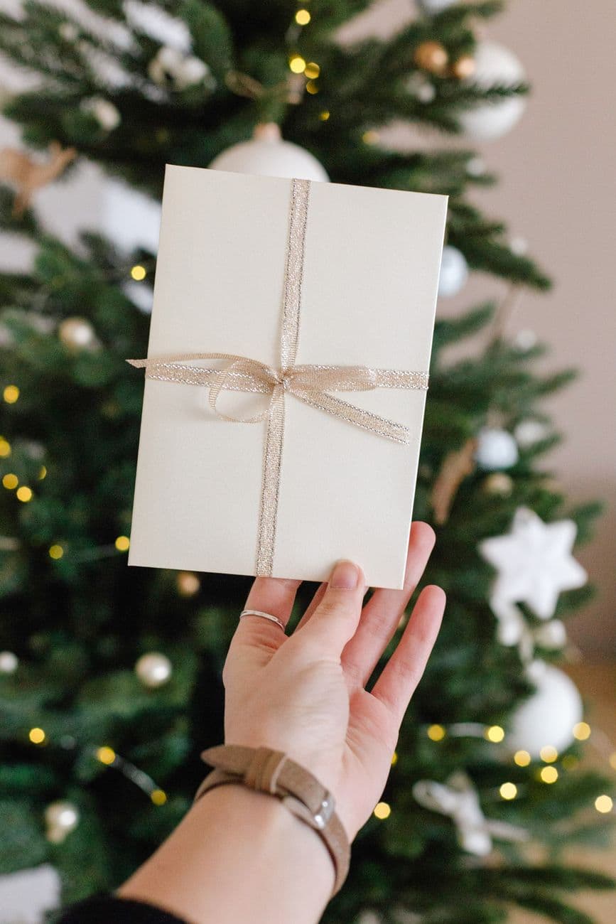 Thoughtful gift package with elegant card held by hand